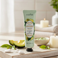 Hand cream with avocado ingredients on a wooden board with avocados and candles in the background