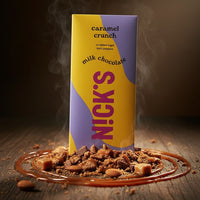 NICK'S caramel crunch milk chocolate packaging with chocolate pieces and caramel on a dark background